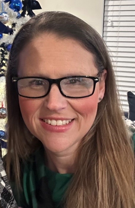 Headshot of Ally Cohen. She is wearing black-rimmed glasses and smiling.