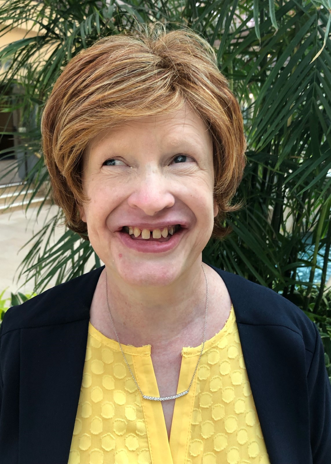 Photo of Jennifer Ottowitz. Jennifer is wearing a yellow blouse with a black jacket, and is smiling.