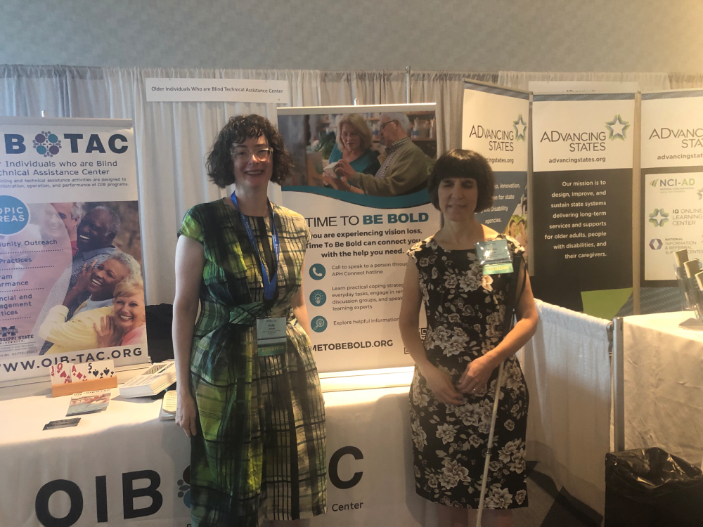 Polly and Kendra standing in front of their booth at the USAging Conference
