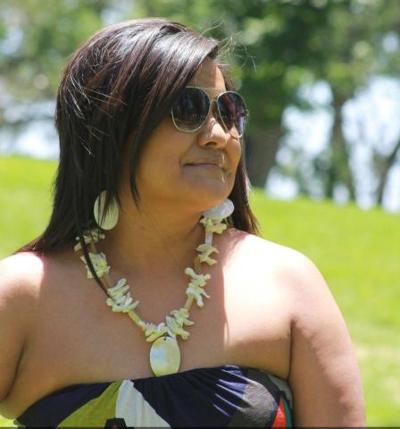 Headshot of Sasheen Smith. She is wearing a tribal necklace and is wearing a long patterned dress.