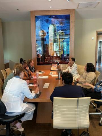 Attendees speaking to each other at a conference table.