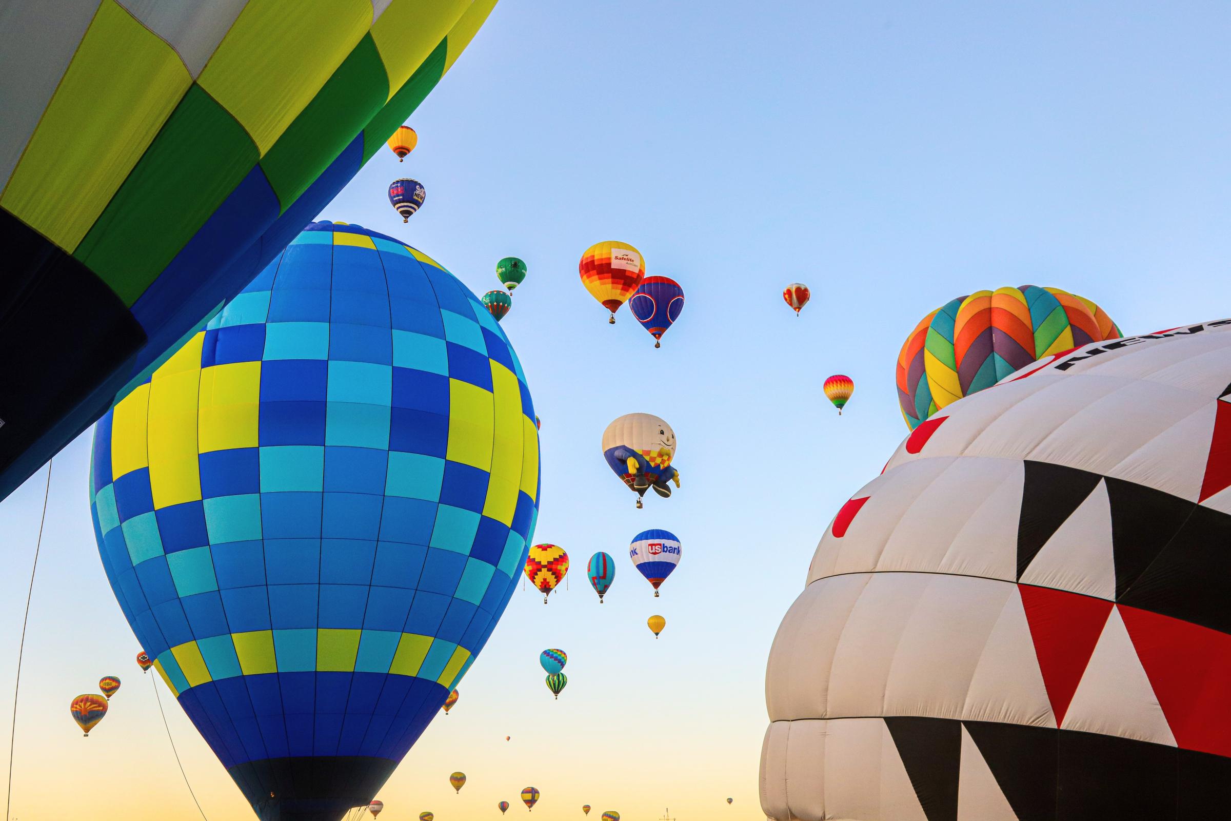 Low Angle Shot Of Airborne Multi-Colored Hot Air Balloons.