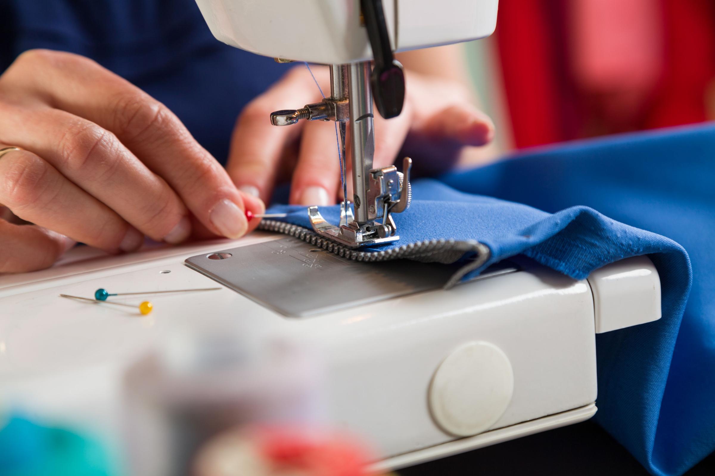 Woman sewing a zipper onto a piece of fabric.
