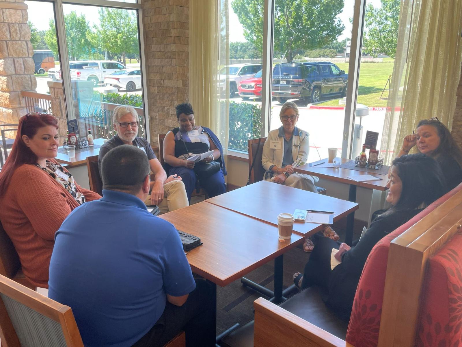Attendees sitting at a coffee table facing each other for a discussion.