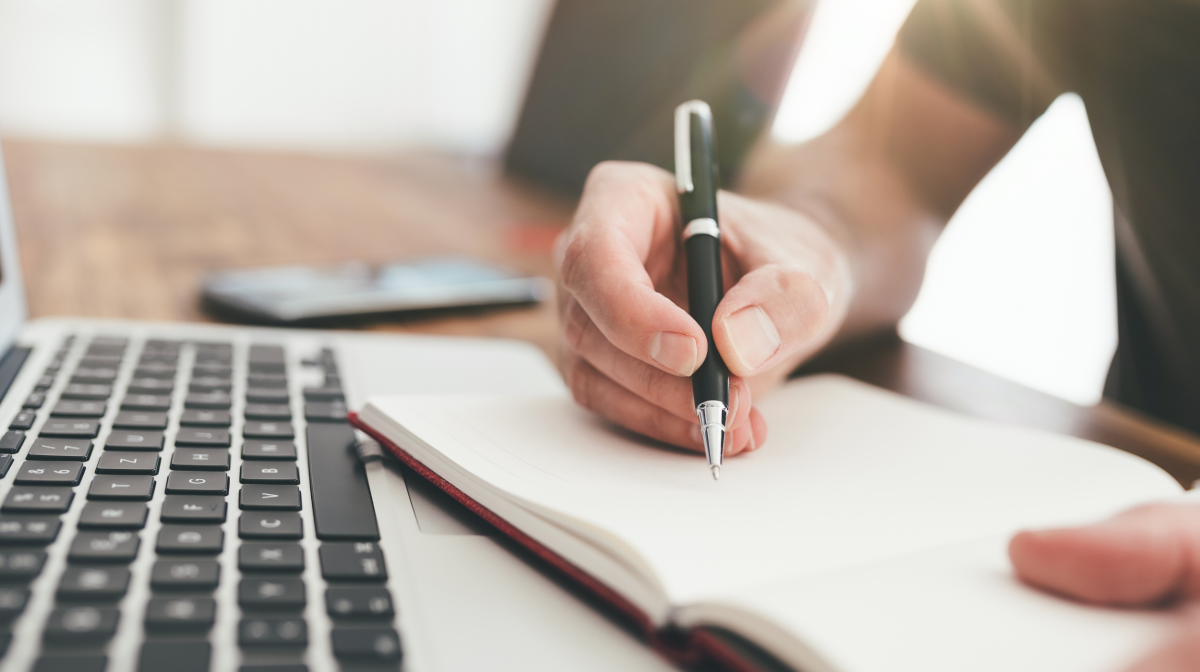 Person writing on a notepad